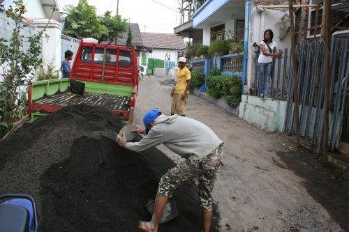 Zand wordt met emmers tegelijk naar binnen gebracht.